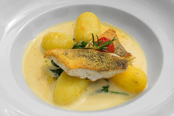 crispy fried pike-perch fillet on spinach leaves buttered potatoes and passion fruit foam