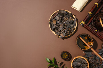 Many black locust fruits placed on bamboo baskets and on the surface. Dipper water scoop displayed with teapot and a teacup. Copy space. Blank space on brown background for product promotion