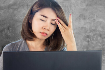 burnout Asian woman have headache migraine while working on computer, stress and fatigue...