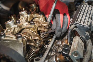 The mechanic is adjusting the valve clearance on a car engine. Auto service. Car repairing. Valve....