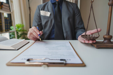 A lawyer or legal advisor prepares to sign legal contract documents. Managing a business with one hand and weighing it with a scale to determine the results of the analysis, principles of legality.