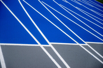 New athletic track background blue and gray with surface texture and crisp white lane lines sports background