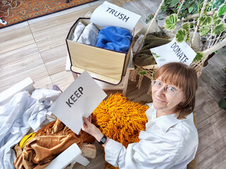 Middle-Aged Woman Sorting Belongings With KonMari Method. Mature woman categorizes items into keep...