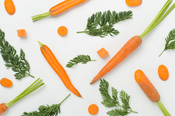 Flat lay with fresh carrots and leaves on white background, top view