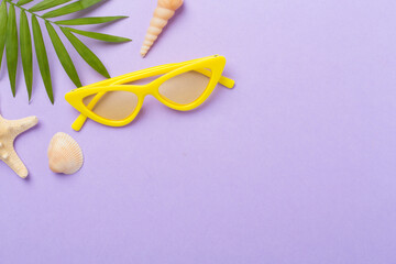 Stylish yellow sunglasses on color background, top view. Summer concept