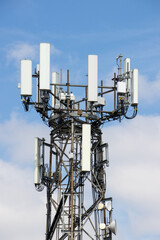 Photo of a mobile telephone communications tower on a sunny summers day with white clouds in the sky