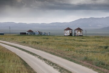 Dirt road and abandoned grain silos in the countryside in Carrizo National Monument, Santa Margarita, California, United States of America. © Zenstratus