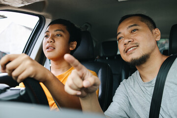 Father Training Son to Driving a Car Carefully, Pointing Finger Giving Direction Inside Car. 