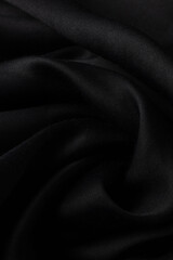 Close up of black silk or satin texture background. Luxury fabric textile for fashion cloth,