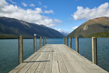 Wooden wharf jetty looking out over lake with mountain view New Zealand