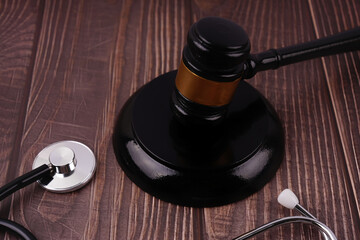 Law and justice concept. A gavel and stethoscope placed on a wooden table.