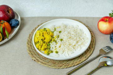 Vegetarian lunch: boiled basmati rice with stewed vegetables - green peas and cauliflower.