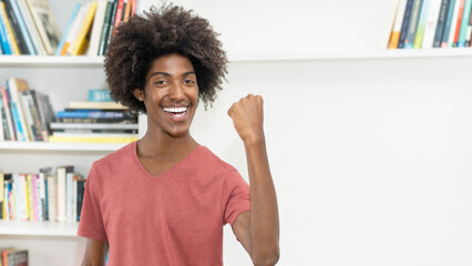 Cheering black male young adult with amazing hairstyle