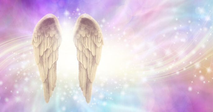 Pale golden sparkling angel wings message background - pair of feathered wings on left with energy flowing through on a pastel  pink and blue ethereal background ideal for a spiritual theme
