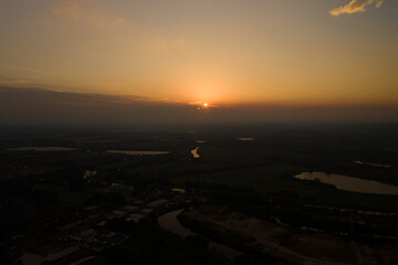 Obraz premium Aerial photo of the beautiful sun setting over the town of Castleford in the district of Wakefield in the UK, showing roof top view of typical British UK rows of houses and streets.