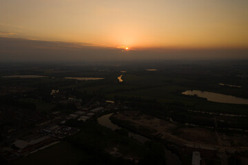 Aerial photo of the beautiful sun setting over the town of Castleford in the district of Wakefield in the UK, showing roof top view of typical British UK rows of houses and streets.