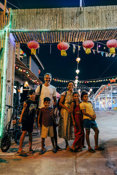 Portrait of happy family standing together at entrance of food market