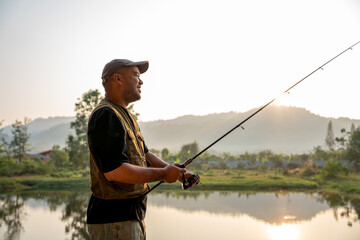 Excited emotion of Handsome fisherman fishing as a leisure activity during his vacation at the lake...