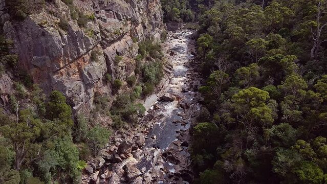 Water stream flowing by the Leven Canyon during daytime in Tasmania, Australia. Drone shot.
.
