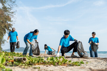 Group teamwork volunteer pick up the plastic bottle on the beach. People male and female Volunteer with garbage bags clean the trash on the beach make the sea beautiful. World environment day CSR.