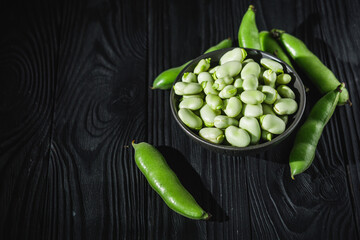 fresh greens broad beans fava on a dark background