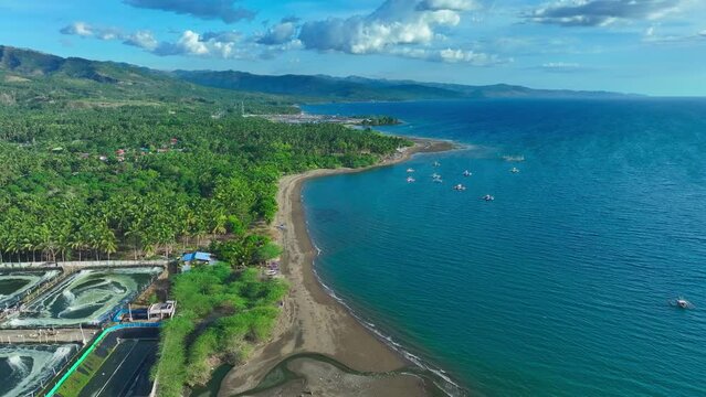 Aerial drone flight over coastline of Sarangani with beach and traditional bangka, fishing boats in south Philippines. Birds eye shot in summer season.