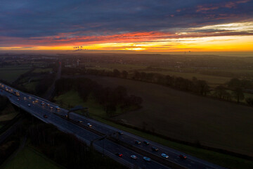 Aerial photo of the town of Garforth in Leeds UK overlooking the motorway at sunset with cars driving on the road while the sun sets in the background