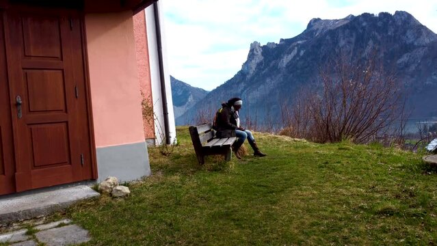 African Tourist in Upper Austria, near Chapel on Kalvarienberg overlooking Traunsee lake in Ebensee, Salzkammergut region, serene mountain backdrop