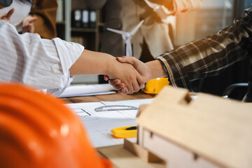 architects and engineers shake hands while working for teamwork and cooperation after completing an...