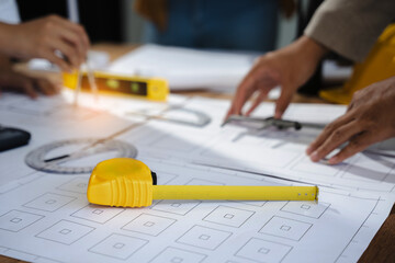 architect or engineer working on table use drawing tool on the paper plan for business...