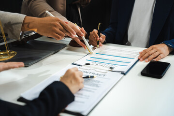 Business people and lawyers discussing contract papers sitting in the table at office in the...