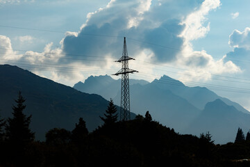 Alpine Silhouette: Power Line Tower Over Forest