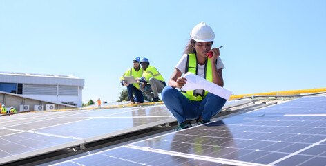 A team of engineers is laying out the installation of an outdoor solar panel system. Installing solar cells on the roof. Solar panels on the roof Workers install eco-technology photovoltaic power plan