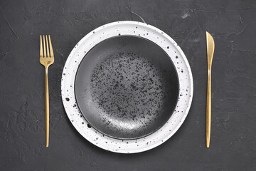 Elegant setting with shiny cutlery on black table, top view