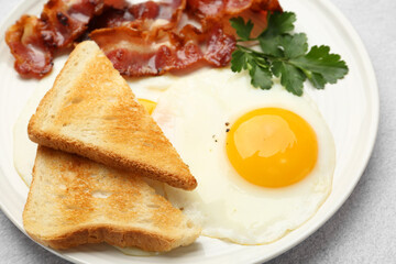 Delicious breakfast with sunny side up egg on light table, closeup
