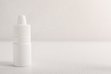 Bottle of medical drops on white background, space for text