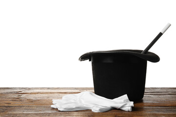 Magician's hat, gloves and wand on wooden table against white background