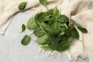 Pile of fresh spinach leaves on light textured table, flat lay