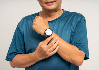 Senior old man wearing sportswear using Smart Watch Showing Heart Rate Monitor on isolated background. Technology for health and sport mode. Exercise and take statistics to develop your potential
