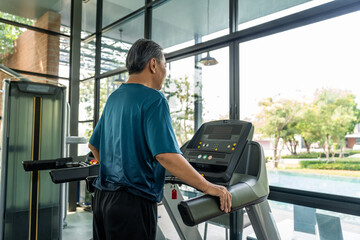 Senior old man runner exercise indoor gym. fitness man jogging wearing sportswear. Mature athlete man in sportswear Workout running on the treadmill.