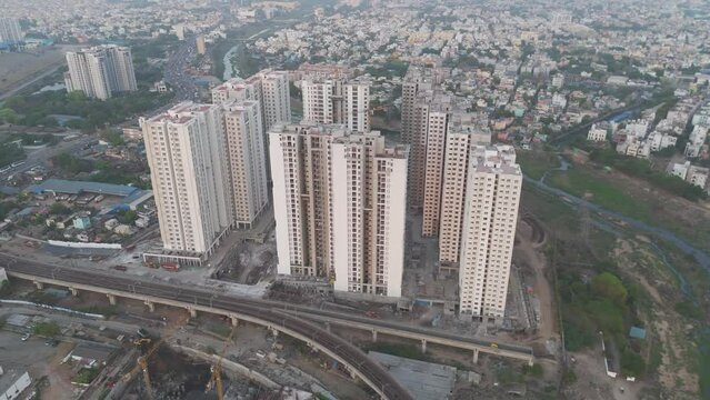 A picturesque drone shot showcasing the architectural diversity of Chennai, from modern skyscrapers to traditional residential houses, all set against a cloudy backdrop.