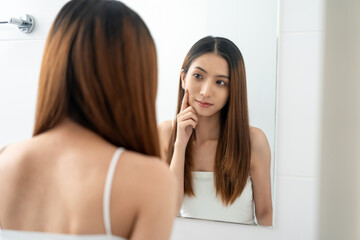 Self confident women look in the mirror brush up their hair and admire their body. Young asian...