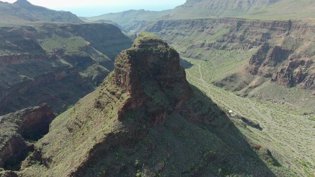 Fantastic aerial view in orbit over the Titana rock on the island of Gran Canaria, seeing beautiful mountains and near the Ansite fortress. Spain.