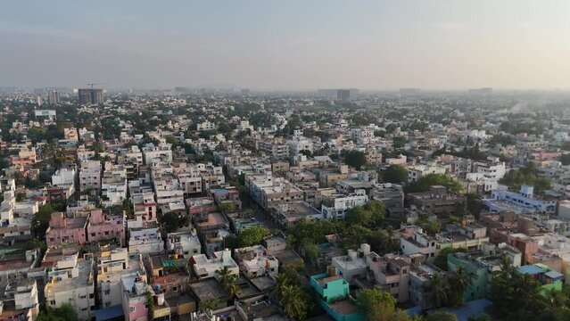 A mesmerizing aerial view of Chennai city, with clouds drifting lazily over the bustling streets and towering skyscrapers, creating a captivating scene.