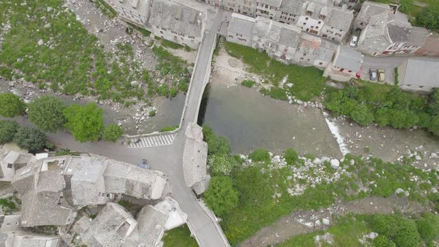 Tarn River Flowing Under Pont de Montvert Bridge At Picturesque French Village - Aerial Topdown