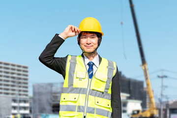 ヘルメットを被った建設・工事現場監督者の男性