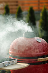 Red Portable Charcoal BBQ Grill Smokes Through Top