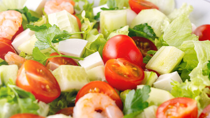 A close-up salad of fresh vegetables, a plate of fresh salad with vegetables and herbs. Greek salad with juicy tomatoes, feta cheese lettuce leaves green olives cucumber, fresh parsley. Homemade food.
