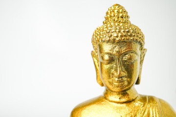 Fototapeta premium A golden statue of a Buddhist figure meditating facing the front isolated on white background. Bodhisattva Face. Concept for Vesak Day and Enlightenment Day