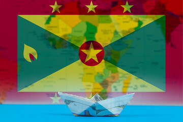 Sea transport of Grenada concept, paper ship with Grenada flag, bulk carrier or ships on sea